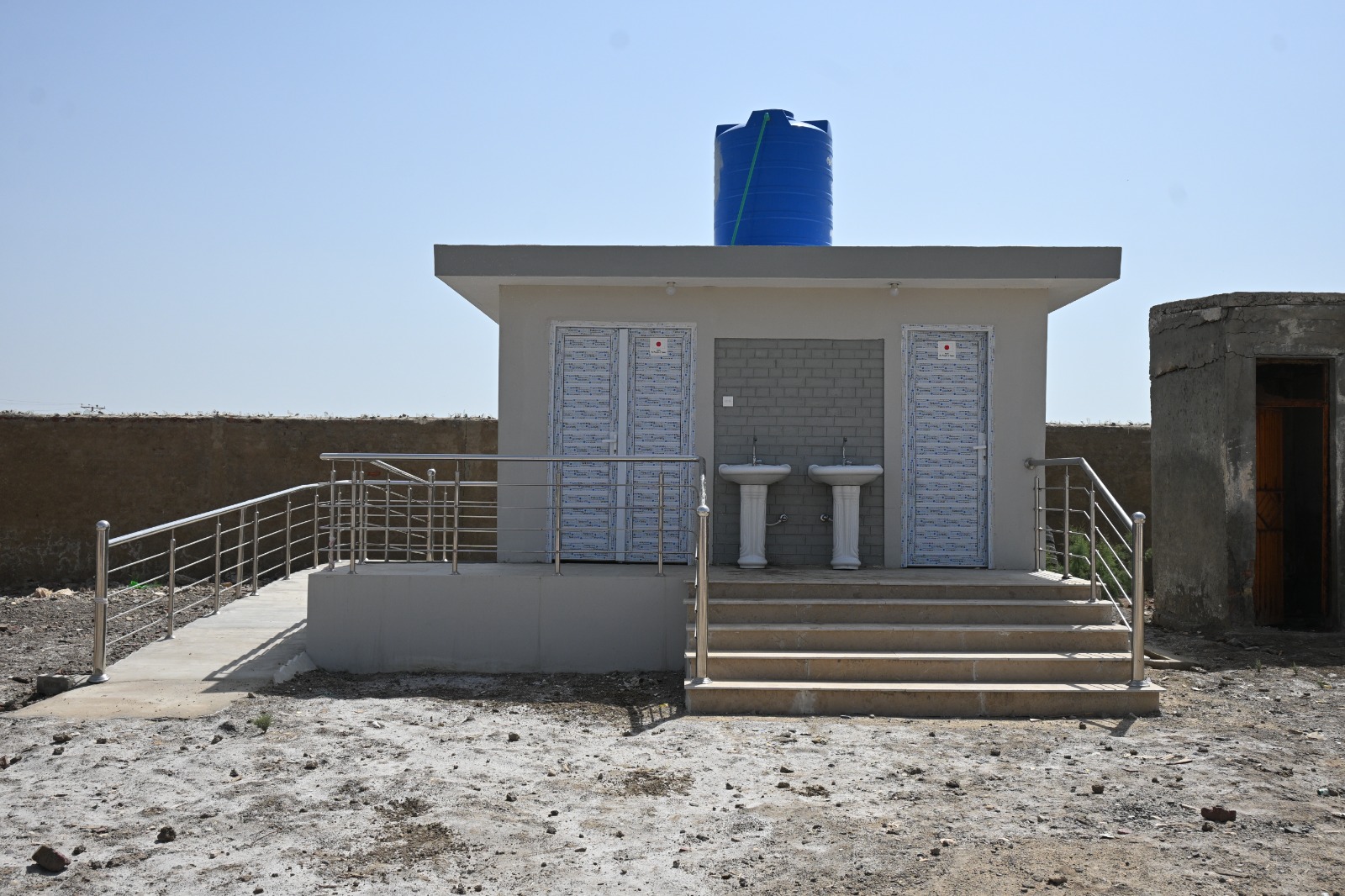 Inclusive WASH — Separate cubicles, ramp-accessible, water-tank fed.